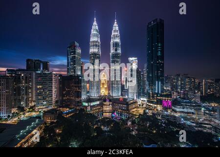 Kuala Lumpur City Centre, noto anche come complesso KLCC, che include le Torri Gemelle Petronas di notte a Kuala Lumpur, Malesia. Foto Stock