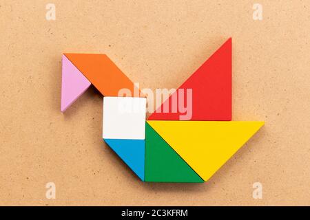 Puzzle tangram colore in cigno o anatra forma su legno bacground Foto Stock