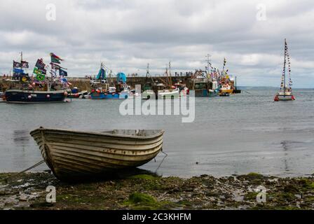 Barche a vela colorate con bandiere colorate sull'acqua vicino un grande molo Foto Stock