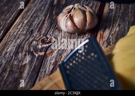 Uno spicchio d'aglio su una superficie di legno arrugginita Foto Stock