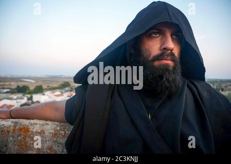 Ritratto di un maschio con bearded che indossa una camicia nera con un cofano Foto Stock