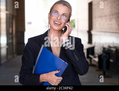 Ritratto di una donna d'affari sorridente che parla telefono all'aperto. Concetto aziendale. Foto Stock