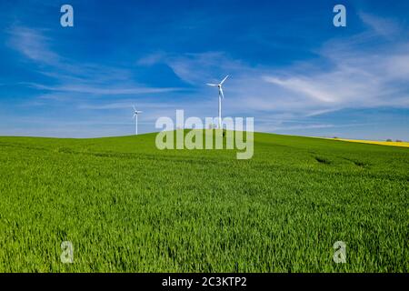 Paesaggio agricolo con due turbine eoliche in lontananza Foto Stock