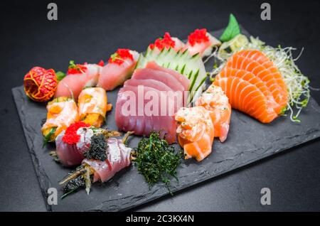 Sushi, cucina tradizionale giapponese. Diversi sushi deliziosi sul piatto decorato, sfondo nero. Gruppo di sushi, Urakami, Nigori, sushi jow, sas Foto Stock