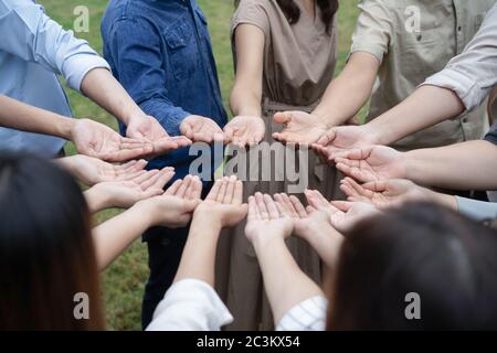 Gruppo di persone asiatiche alzano le mani giuste e si maneggiano delicatamente per ottenere e condividere una buona sensazione di gether in formazione Teambuilding. Foto Stock