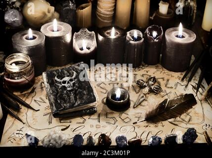 Libro male con incantesimi neri magici, candele e tavolo ouija sulla tavola  delle streghe. Wicca, sfondo esoterico e occulto con oggetti magici vintage  per mistici Foto stock - Alamy
