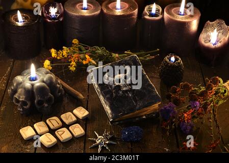 Candele nere, rune, vecchio libro di streghe ed erbe su tavola di legno.  Wicca, sfondo esoterico e occulto con oggetti magici vintage per rituali  mistici. H Foto stock - Alamy