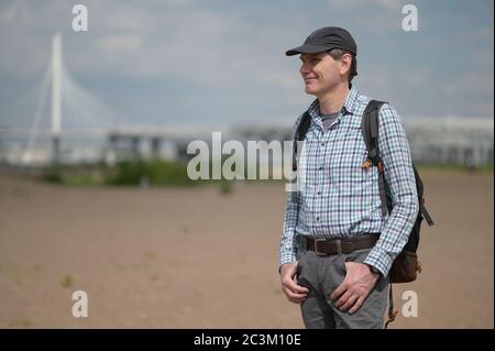 Solo uomo caucasico maturo con zaino in piedi sulla spiaggia di San Pietroburgo, Russia Foto Stock