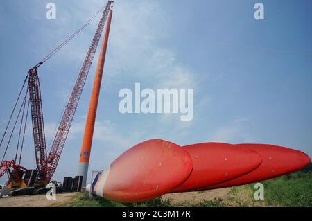 (200621) -- QINHUANGDAO, 21 giugno 2020 (Xinhua) -- Foto scattata il 20 giugno 2020 mostra il sito di costruzione della seconda fase di un progetto di energia eolica nella contea di Changli di Qinhuangdao, provincia di Hebei, nella Cina settentrionale. Il sollevamento e l'installazione di turbine eoliche nella seconda fase del progetto eolico è ufficialmente iniziato di recente. Il progetto di energia eolica, con un investimento pianificato di 1.696 miliardi di yuan (circa 240 milioni di dollari), sarà costruito in due fasi. Dopo il completamento dell'intero progetto, sarà in grado di generare 600 milioni di kilowattora di potenza p Foto Stock