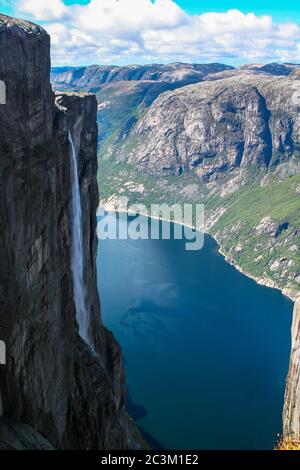 Vista aerea del Lysefjorden da Kjeragbolten, con cascata sulla scogliera e le montagne sullo sfondo, sulla montagna Kjerag Forsand in comune Foto Stock