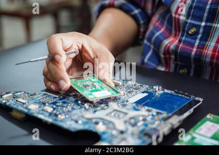 Asian tecnico riparazione circuito micro scheda principale del computer tecnologia elettronica : hardware, telefono cellulare, aggiornamento, concetto di pulizia. Foto Stock