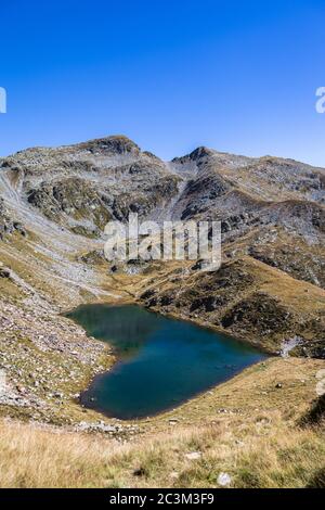 Vista mozzafiato ariel del lago Lagh de Calvaresc a forma di cuore, nelle Alpi svizzere, sul sentiero escursionistico di Sentiero Calanca, in una giornata di sole estivo, Cant Foto Stock