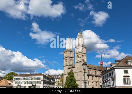 Vista ravvicinata della chiesa di Grossmuenster (Grossmunster) e Wasserkirche (chiesa sull'acqua) sul lato del fiume Limmat dal ponte Muenster sulla soleggiata da estiva Foto Stock