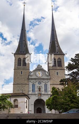 Vista esterna della chiesa di San Leodegar (Hofkirche), una chiesa cattolica romana nel centro storico di Lucerna in una giornata estiva soleggiata con nuvola blu nel retro Foto Stock