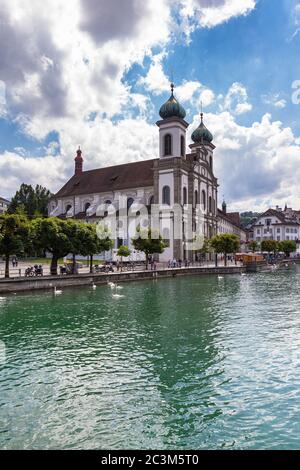 Bella vista della chiesa gesuita di Lucerna (Gesuitenkirche) sul lato del fiume Reuss nel centro storico di Lucerna con riflessione in acqua, su una soleggiata da estiva Foto Stock