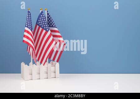 Composizione creativa con due bandiere americane su tavola bianca con sfondo blu con copyspace per il testo. Simbolo nazionale degli Stati Uniti - bandiera Old Glory Foto Stock