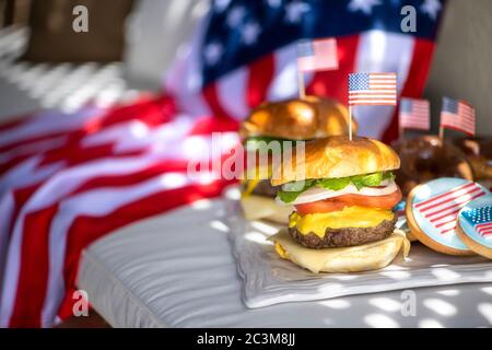 Due hamburger americani con bandiera americana su di loro e una bandiera americana per sfondo per il 4 luglio Foto Stock