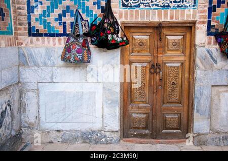 Porta antica con tradizionale scultura decorativa in legno in Piazza Registana a Samarkand, Uzbekistan Foto Stock