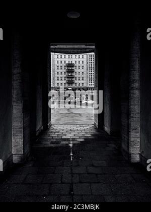 Immagine verticale in scala di grigi di una strada e degli edifici catturati da un tunnel Foto Stock