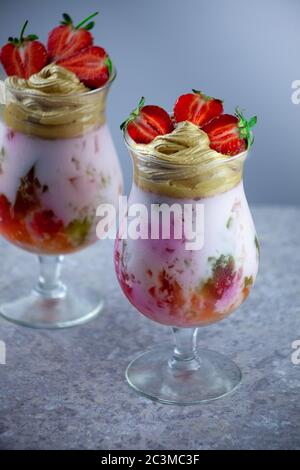 Dessert estivo freddo. Ciotole di gelatina stratificata servite sul tavolo su sfondo chiaro. Cocktail colorato e festoso con gelatina di dolci in vetro Foto Stock