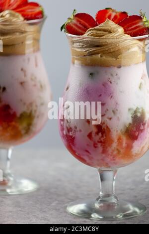 Dessert estivo freddo. Ciotole di gelatina stratificata servite sul tavolo su sfondo chiaro. Cocktail colorato e festoso con gelatina di dolci in vetro Foto Stock