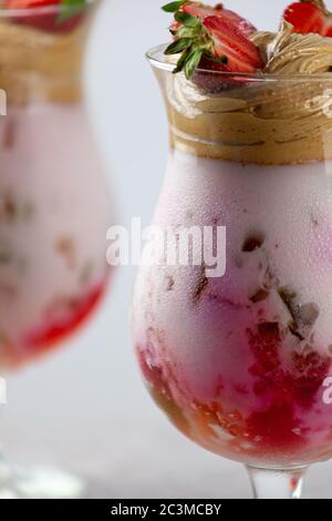 Dessert estivo freddo. Ciotole di gelatina stratificata servite sul tavolo su sfondo chiaro. Cocktail colorato e festoso con gelatina di dolci in vetro Foto Stock