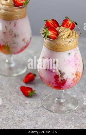 Dessert estivo freddo. Ciotole di gelatina stratificata servite sul tavolo su sfondo chiaro. Cocktail colorato e festoso con gelatina di dolci in vetro Foto Stock