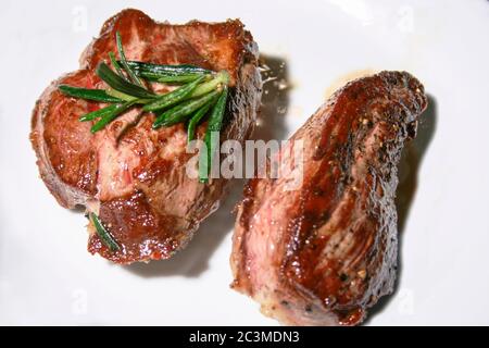 agnello marinato e cotto con rosmarino su fondo bianco Foto Stock