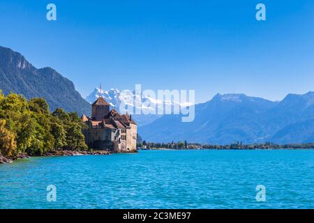 Bella vista del castello di Chillon sul lato lago del lago di Ginevra, con le cime del Midi delle Alpi svizzere in background, Montreux, Canton Vaud, Foto Stock