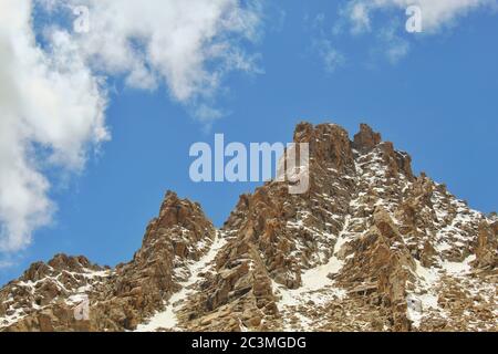 vista panoramica di una montagna con cielo blu e nuvole sopra. Foto Stock
