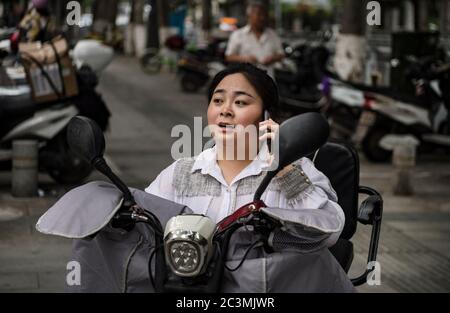 (200621) -- ANKANG, 21 giugno 2020 (Xinhua) -- li Dan contatta un cliente che ha fatto un ordine su WeChat prima di consegnare i prodotti nel villaggio di Wenhua nel distretto di Hanbin della città di Ankang, nella provincia di Shaanxi, nella Cina nord-occidentale, 19 giugno 2020. Nel 1997, per sventolare la povertà, li Zengyi, un abitante del villaggio di Wenhua, nella città di Ankang, trasferì la sua famiglia, compresa la sua figlia di sette anni disabile, in una casa di fortuna su una montagna per coltivare le pesche. Li Wei, il figlio maggiore di li Zengyi, uscì a lavorare nella provincia di Guangdong, in Cina meridionale, dopo la laurea dalla scuola media per sostenere la famiglia. Foto Stock