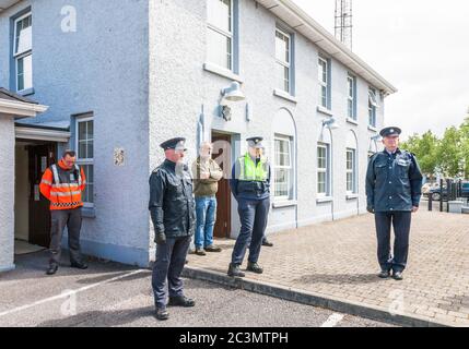 Carrigaline, Cork, Irlanda. 21 Giugno 2020. I membri di un Garda Síochána, soccorritori e cittadini osservano un minuto di silenzio alle 12 fuori dalla stazione di Carrigaline Garda in Co. Cork, come segno di rispetto per il detective Garda Colm Horkan, assassinato in linea di servizio la scorsa settimana. - credito; David Creedon / Alamy Live News Foto Stock