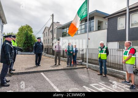 Carrigaline, Cork, Irlanda. 21 Giugno 2020. I membri di un Garda Síochána, soccorritori e cittadini osservano un minuto di silenzio alle 12 fuori dalla stazione di Carrigaline Garda in Co. Cork, come segno di rispetto per il detective Garda Colm Horkan, assassinato in linea di servizio la scorsa settimana. - credito; David Creedon / Alamy Live News Foto Stock