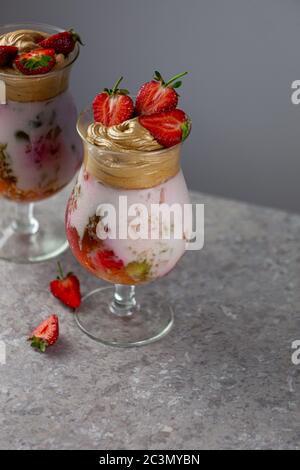 Dessert estivo freddo. Ciotole di gelatina stratificata servite sul tavolo su sfondo chiaro. Cocktail colorato e festoso con gelatina di dolci in vetro Foto Stock