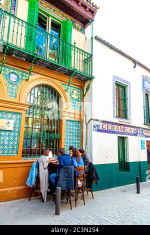 Persone che mangiano all'aperto al ristorante Alfarería 21 in Ceramica artistica restaurata, edificio M G Montalvan a Triana, Calle Alfareria, Siviglia, Spagna Foto Stock