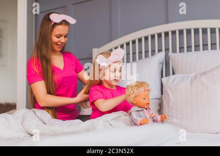 Mamma combatte la figlia mentre gioca con la bambola Foto Stock