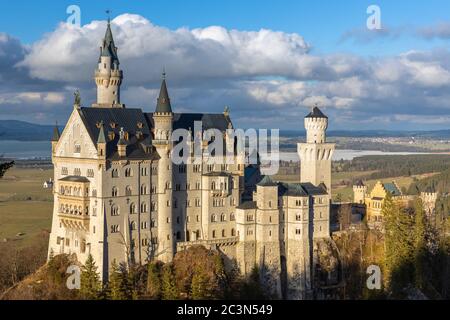 Vista ravvicinata del famoso Castello di Neuschwanstein al tramonto in inverno, con il sole e il lago di Forggensee sullo sfondo, Schwangau, Baviera, Foto Stock