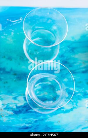 Due vetri su una superficie con resina epossidica ART con inchiostri a base di alcool blu Foto Stock