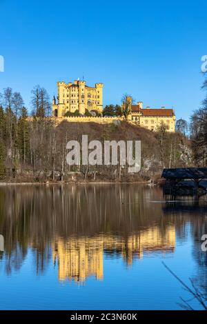 Vista mozzafiato sul lago Alpsee in inverno in una giornata di sole con il Castello di Hohenschwangau e le Alpi Bavaresi sullo sfondo, con bellissimi riflessi Foto Stock