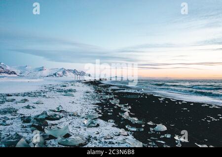 Vista su Diamond Beach in Islanda con cubetti di ghiaccio al suolo Foto Stock