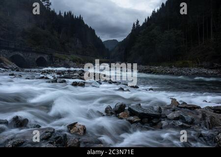 Fiume vicino cascata Latefossen a lunga esposizione in chiaro clima nuvoloso scuro. Acqua soffice e setosa nella valle di Odda, Norvegia Foto Stock