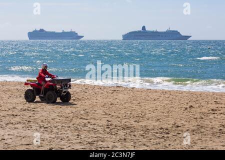 Bournemouth, Dorset UK. 21 giugno 2020. I bagnini RNLI tornano in servizio in alcune delle spiagge di Bournemouth, poiché le temperature si innalzano durante la settimana per una mini ondata di caldo che attrarrà folle sulle spiagge. RNLI Lifeguard guida Honda TRX quad lungo la spiaggia. Credit: Carolyn Jenkins/Alamy Live News Foto Stock