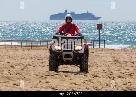 Bournemouth, Dorset UK. 21 giugno 2020. I bagnini RNLI tornano in servizio in alcune delle spiagge di Bournemouth, poiché le temperature si innalzano durante la settimana per una mini ondata di caldo che attrarrà folle sulle spiagge. RNLI Lifeguard guida Honda TRX quad lungo la spiaggia. Credit: Carolyn Jenkins/Alamy Live News Foto Stock