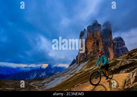 Uomo in bicicletta elettrica, passeggiate in mountain trail. Uomo in bicicletta nel paesaggio delle Dolomiti. Pista ciclabile e-mtb enduro. spo per esterni Foto Stock