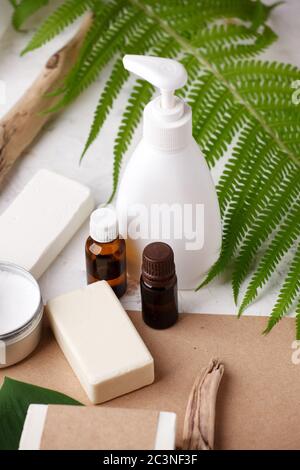 Accessori naturali per il bagno e cosmetici per la cura della pelle - sapone solido e shampoo, spazzolini da denti di bambù, oli essenziali, tema zero rifiuti su sfondo beige. Foto Stock