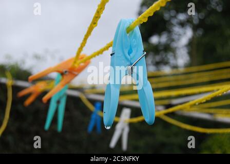 Primo piano di un sacco di colorful clothespins su giallo cavi Foto Stock