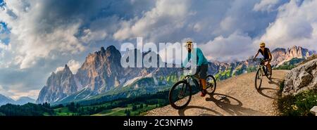 Ciclismo donna e uomo in bicicletta in Dolomiti montagna andscape. Coppia ciclabile MTB enduro pista. Attività sportive all'aperto. Foto Stock