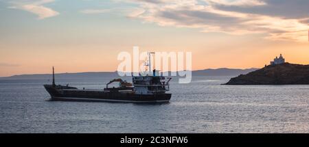 Nave su mare calmo al tramonto nel Mar Mediterraneo Egeo, Grecia. Faro su un capo a Kea Island Foto Stock