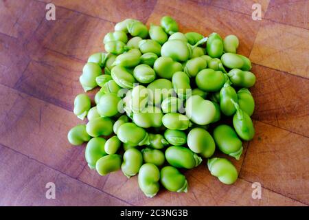 Fagioli appena raccolti su una tagliere di legno - John Gollop Foto Stock