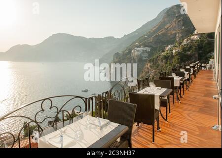 Ristorante con vista in un hotel a Praiano vicino Positano in attesa di cena ospiti. La panoramica costiera amalfitana è una delle principali destinazioni turistiche d'Italia Foto Stock